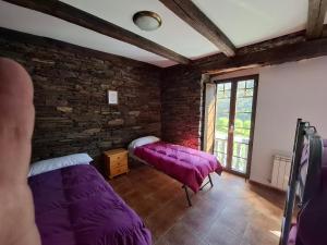 a room with two beds and a purple blanket at Albergue Val de Samos in Samos +51 photos