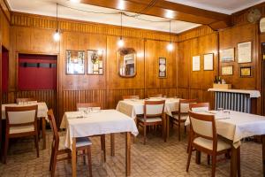 a dining room with tables and chairs and wooden walls at Albergo Ristorante Badellino dal 1917 in Bra