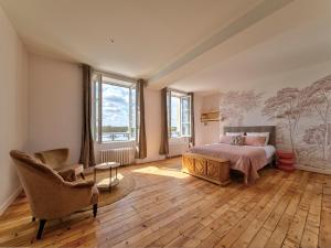 a bedroom with a bed and a chair at La ROCHE D'ANJOU in Saint-Mathurin +32 photos