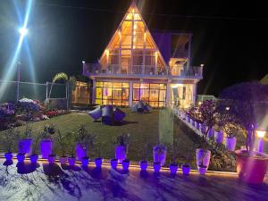 a house with purple pots in front of it at night at thesukoon in Bhīm Tāl +1 photo