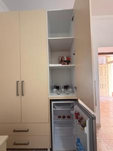 a small kitchen with an empty refrigerator in it at Merkaj House in Berat