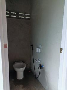 a bathroom with a toilet and a hose at Maybeth Haven Cabin in Baler