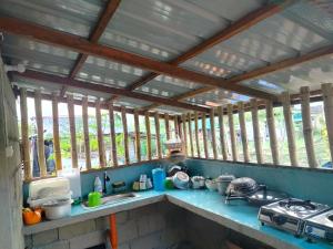 a kitchen with windows and a sink and a stove at Maybeth Haven Cabin in Baler