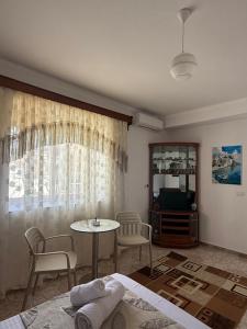 a bedroom with a table and chairs and a television at Merkaj House in Berat