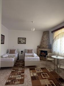 a living room with two beds and a fireplace at Merkaj House in Berat