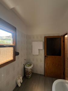 a bathroom with a toilet and a window and a door at Merkaj House in Berat +26 photos
