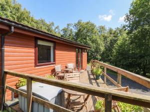 a cabin in the woods with a deck at Thistle Lodge in Dunoon