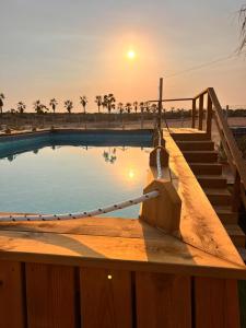 a swimming pool with a sunset in the background at Lomas de Balsares in Elche