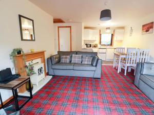 a living room with a couch and a table at Thistle Lodge in Dunoon