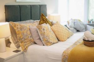 a couch with a bunch of pillows on it at The Nest - Chandlers in Rothesay