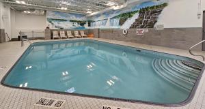 a large swimming pool in a gym with chairs at Vittoria Hotel & Suites in Niagara Falls