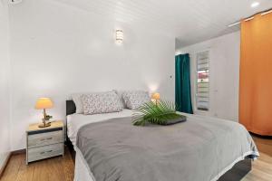 a bedroom with a large bed with a plant on it at Modern Villa with Pool & Garden in Farehau