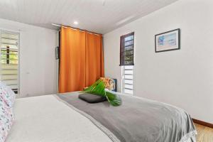 a bedroom with a bed with an orange curtain at Modern Villa with Pool & Garden in Farehau +37 photos