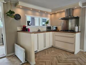 a kitchen with white cabinets and a counter top at Madeliefje - Familie camping in Raalte in Raalte