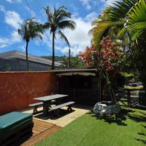 a backyard with a picnic table and palm trees at Recanto do Capitão in Rio de Janeiro