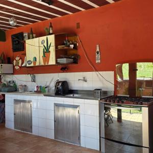 a kitchen with red walls and a stove top oven at Recanto do Capitão in Rio de Janeiro