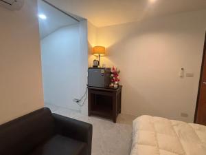 a bedroom with a bed and a tv in a room at Baan Kru Ju Single Room in Phuket