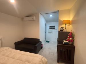 a bedroom with a bed and a chair in it at Baan Kru Ju Single Room in Phuket