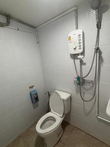 a bathroom with a toilet and a shower at Baan Kru Ju Single Room in Phuket