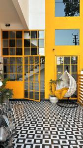 a yellow building with a chair and a plant in front at Bingo Service Apartment Grand 3BHK in Alwar +4 photos