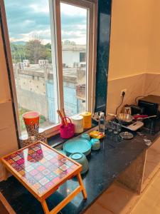 a kitchen counter with a table and a window at Bingo Service Apartment Grand 3BHK in Alwar