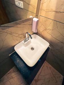 a white sink in a bathroom with a mirror at Bingo Service Apartment Grand 3BHK in Alwar