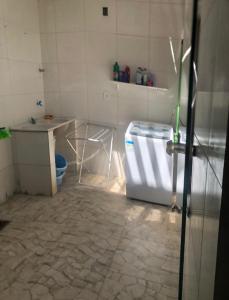 a kitchen with a refrigerator and a table in a room at Aluguel de quarto com suite in Aracaju +5 photos