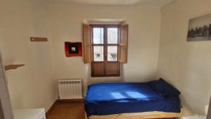 a bedroom with a blue bed and a window at Rural house in Villabasil