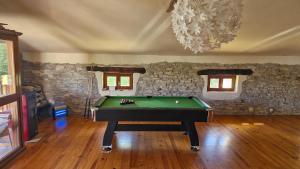 a room with a pool table and a stone wall at Rural house in Villabasil