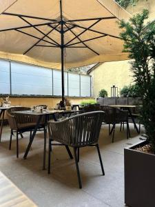 a patio with tables and chairs with an umbrella at Calepina Alpine Suite in Trento