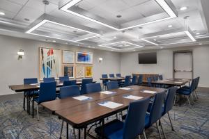 a conference room with tables and chairs and a screen at Holiday Inn Express & Suites Terre Haute by IHG in Terre Haute +69 photos