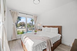 a white bedroom with a bed and a large window at Sun Fun in Myrtle Beach +91 photos