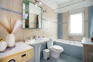 a bathroom with a sink and a toilet and a tub at Villa Aurum in Prinos +38 photos