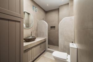 a bathroom with a sink and a toilet and a mirror at Rada Residence in Livadi +24 photos