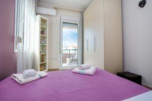 a bedroom with two pink pillows on a purple bed at Villa Aurum in Prinos