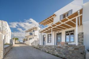 a white house with a stone wall at Rada Residence in Livadi