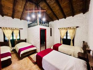 a bedroom with two beds in a room at Posada de Aquilino MC in Cucunubá