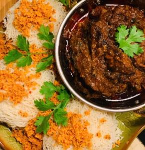 a plate of food with a bowl of meat and rice at Colombo Residency -Pent House in Kotuwegoda +18 photos