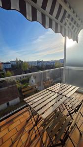 a table and chairs on a balcony with an umbrella at Le haie vigné in Caen