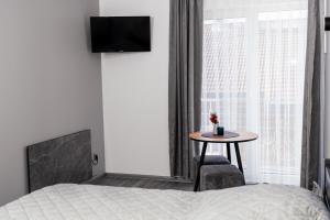 a bedroom with a bed and a table next to a window at Котедж у Русина in Pilipets