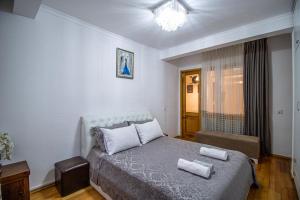 a bedroom with a bed with two towels on it at Cozy Apartment on Kostava in Tbilisi City