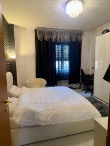 a bedroom with a large white bed and a window at private room in a shared apartment in Seveso