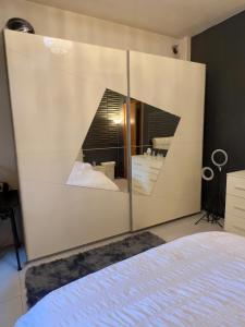 a bedroom with a large white wall with a mirror at private room in a shared apartment in Seveso