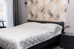 a bed in a bedroom with a wall with feathers at Котедж у Русина in Pilipets