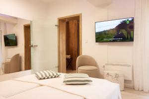 a room with a bed and a tv on the wall at Apartmani Enna in Mali Lošinj