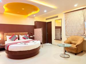 a hotel room with a bed and a chair at Hotel Rajdoot Royale by Ambai in Ichalkaranji +97 photos