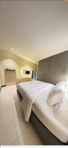 a bedroom with a large white bed in a room at Hotel Mario Parepare in Parepare