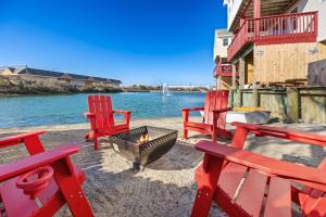 a group of red chairs and a fire pit next to the water at 5066 - McBride's Shore Thing 2 in Kill Devil Hills