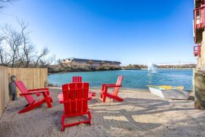 two red chairs and a boat on a beach at 5066 - McBride's Shore Thing 2 in Kill Devil Hills