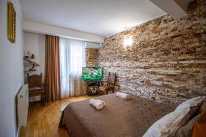 a bedroom with a brick wall and a bed at Cozy Apartment on Kostava in Tbilisi City
